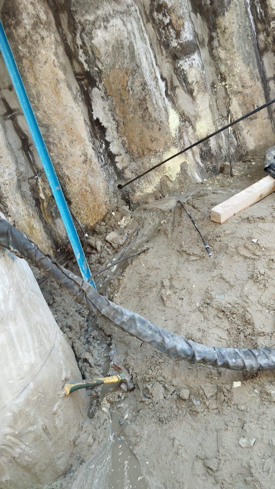 Localized seepage and wet ground at the base of the shoring wall.