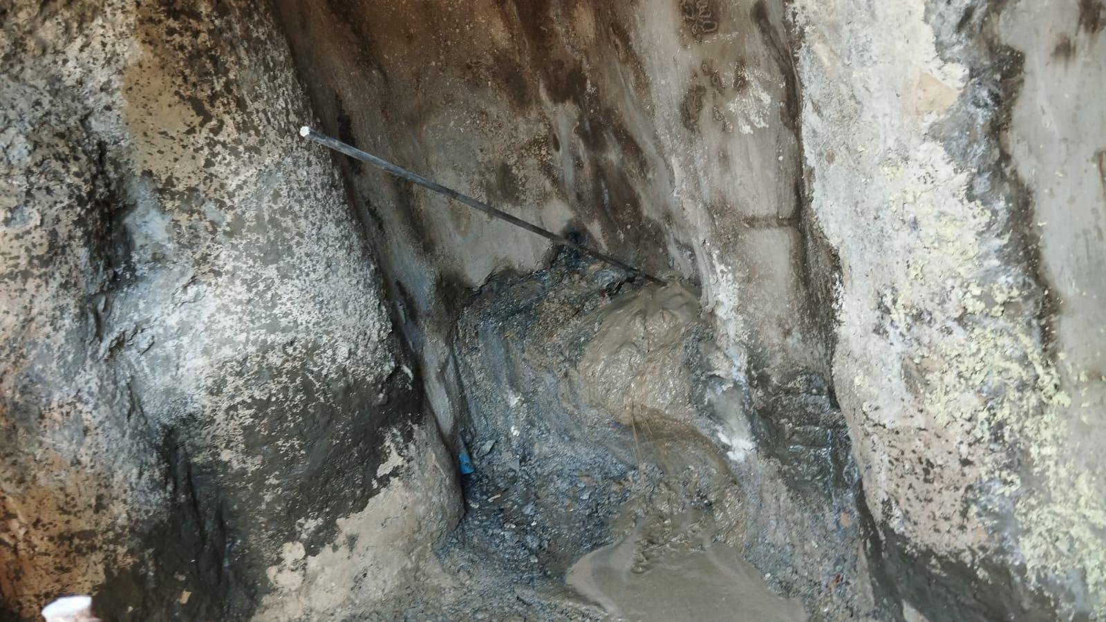 lose-up site condition showing active wet seepage at the wall-base interface during treatment operations.