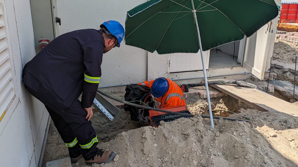 Geobear techs working in a building's sandy soil foundation