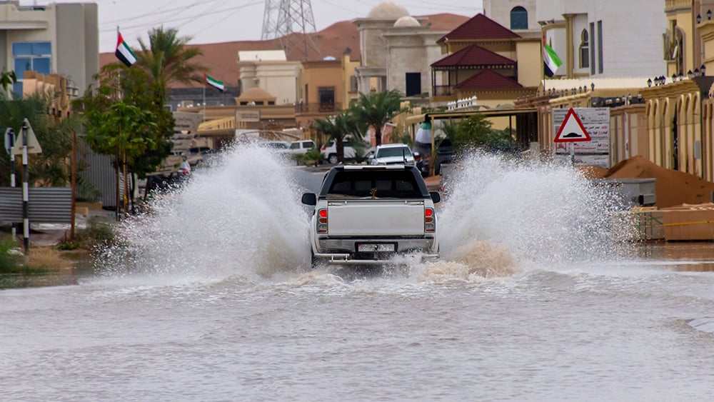 Flooded street in Dubai with truck driving in water filled street