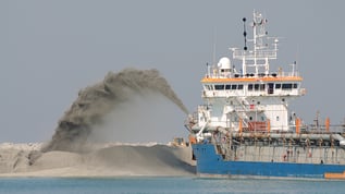 Ship is shooting sand from the sea bottom to land