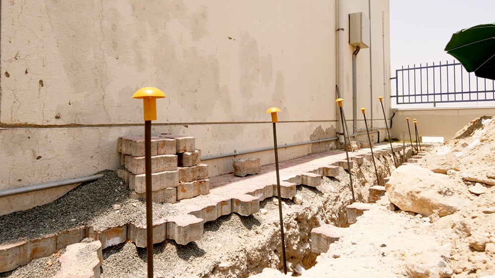 UAE side of villa with brickwork removed and injection tubes inserted into the soil.