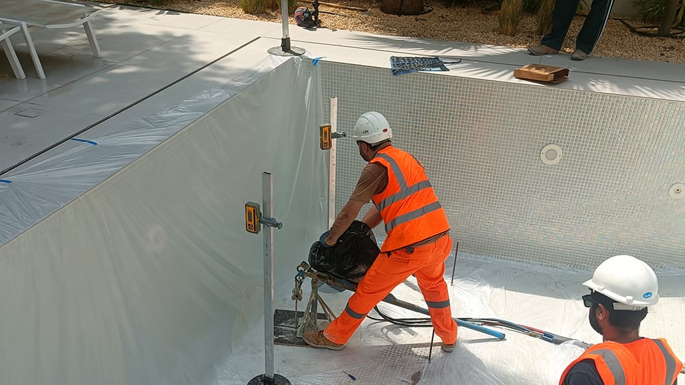 Geobear techs working in a drained swimming pool