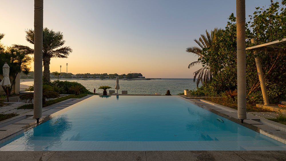 Sunset view overlooking swimming pool to the sea of private villa in UAE