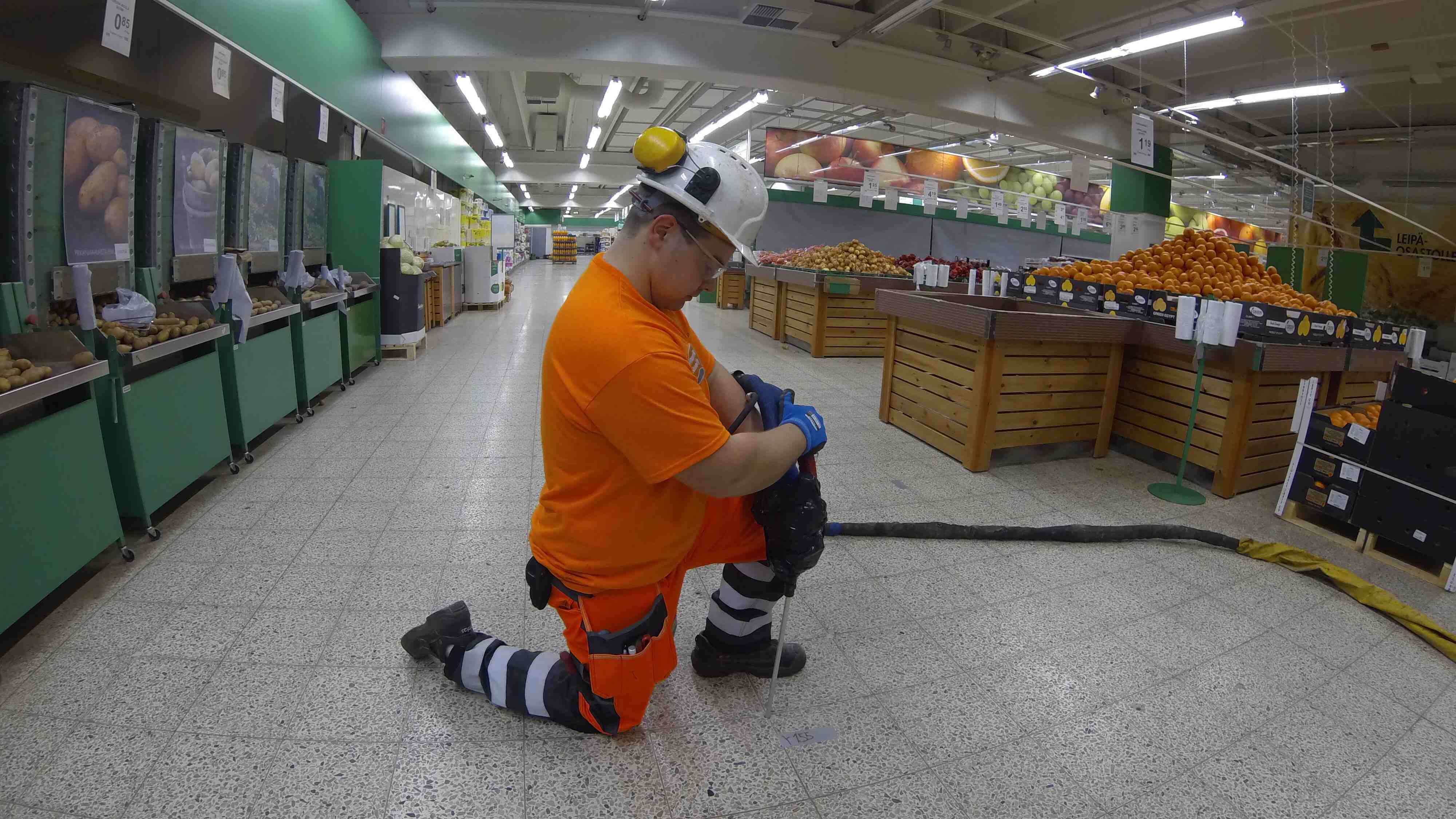 Näkymä Prisman hedelmä- ja vihannesosastolle, jossa Geobearin asentaja injektoi lattian alle geopolymeeriä ohuen injektointipillin kautta.
