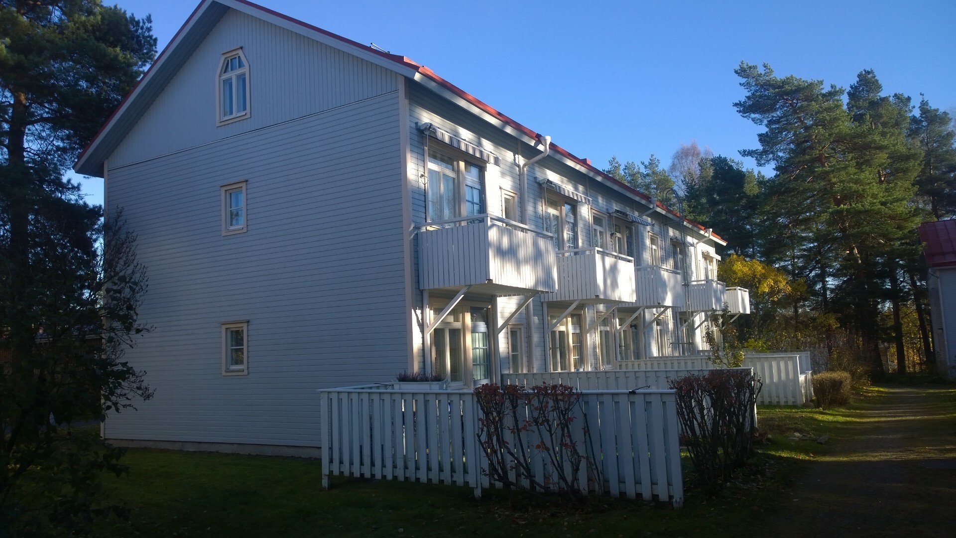 Viiden asunnon pienkerrostalo ilta-auringossa.