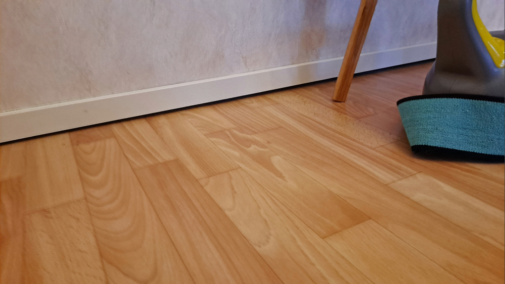 Lähikuva jalkalistan ja lattian välissä olevasta pienestä raosta.
