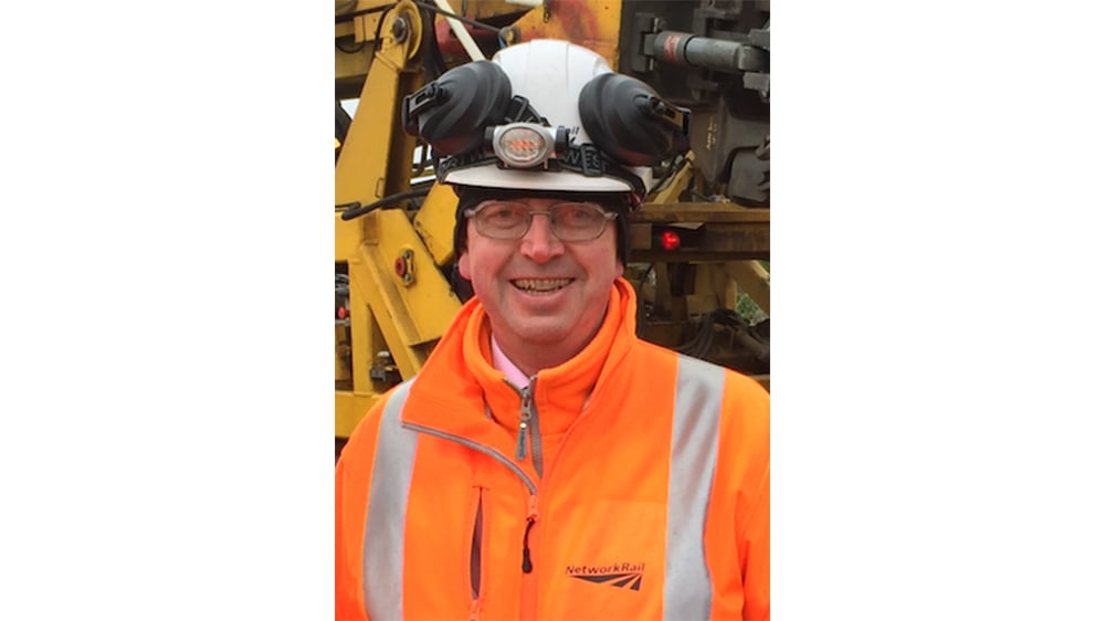 A photo of Steve Featherstone in work PPE smiling at the camera