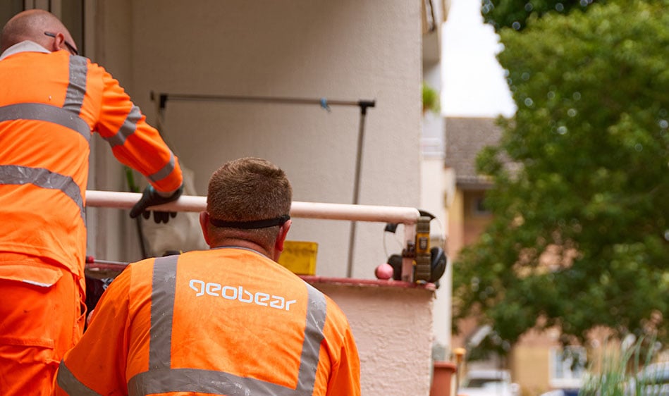 Geobears tekniker i orangea skyddskläder på plats för att injektera geopolymer