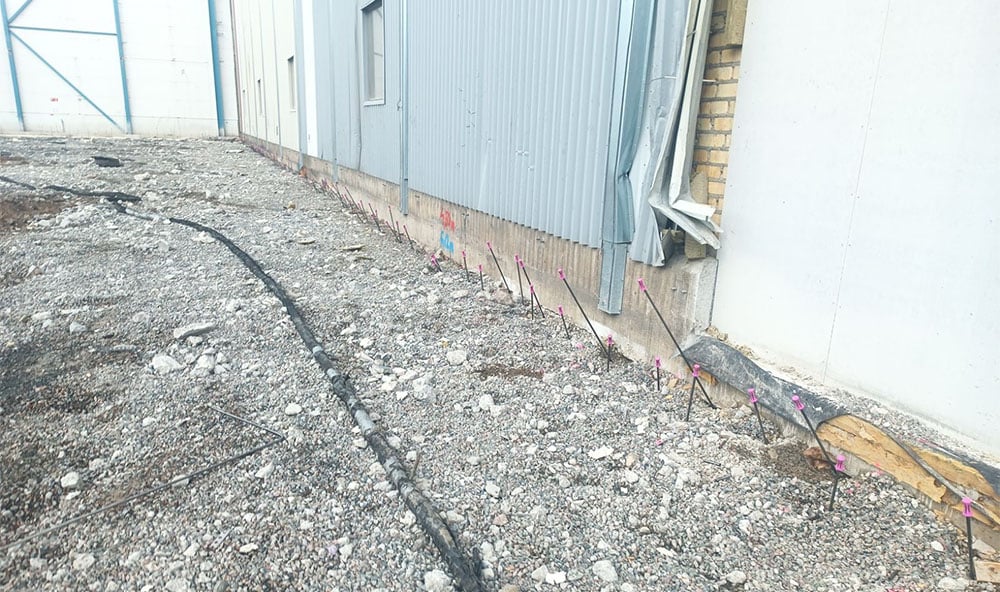 Markförstärkning och stabilisering av grunden utförs precis intill den befintliga fabriksbyggnaden i Ludvika för att säkra konstruktionen mot underminering inför Hitachi Energys stora utbyggnad.