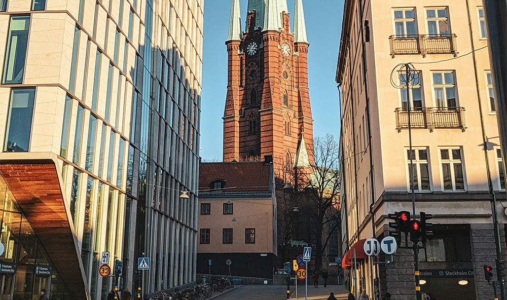 Kyrka i centrala Stockholm som tittar fram bakom husen i city.