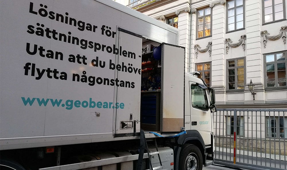 Geobears lastbil framför en äldre vacker byggnad.