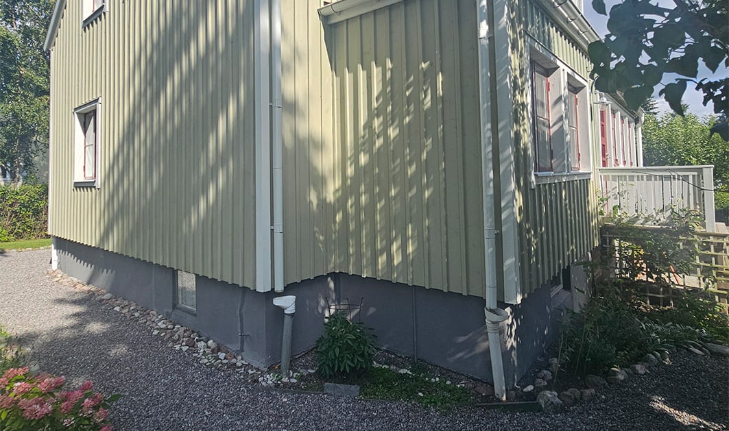 Närbild på trävilla i Spånga och dess grund som har sprickor och sättningar.