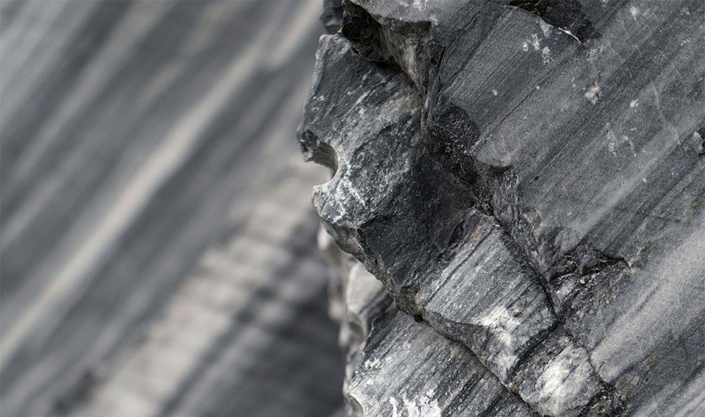 Metamorfa bergarter som marmor och kvartsit med hög tryckhållfasthet och naturliga sprickor som påverkar markens bärighet vid grundläggning.