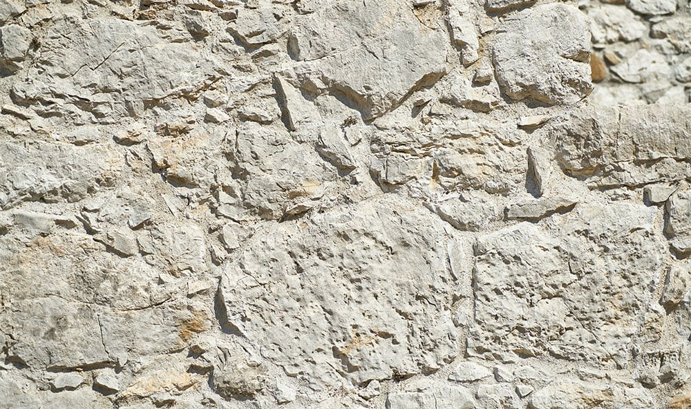 Sedimentära bergarter som skiffer och kalksten med naturliga hålrum och skiktningar som kan påverka markens bärighet under husgrunder.