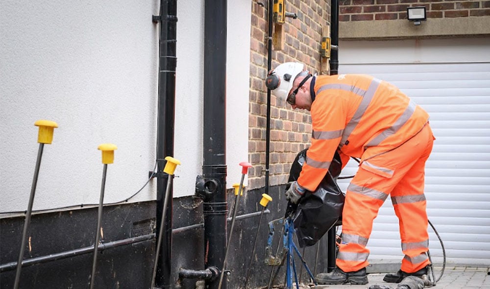 Geobears tekniker i oranges kläder på plats för att utföra markförstärkning med geopolymer