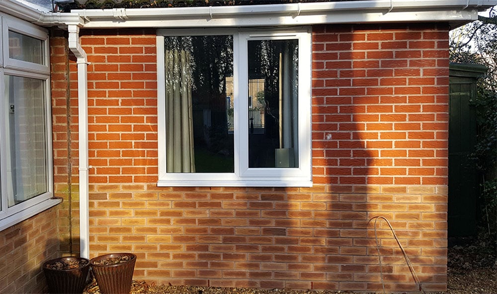 En sjunkande utbyggnad på ett orange tegelhus orsakat av sättningar.