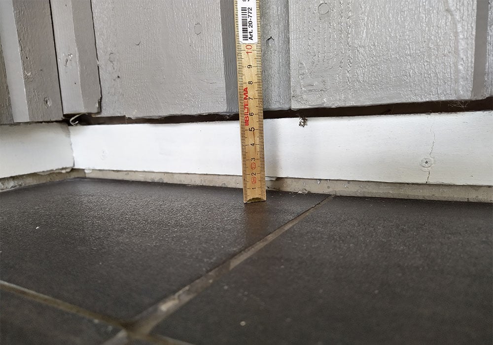 En tydlig sättningsskada i ett uterum i en villa i Norrtälje där glaspartier hänger i luften på grund av svag mark i den sandiga moränen.