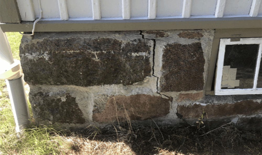 Spricka på utsida husvägg orsakat av sättningar.
