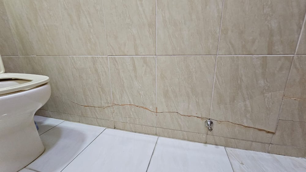 Horizontal crack in villa wall - internal cracking across tiling