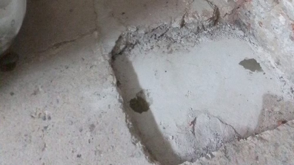 Close up view of cement floor with patches where injection points were inserted.
