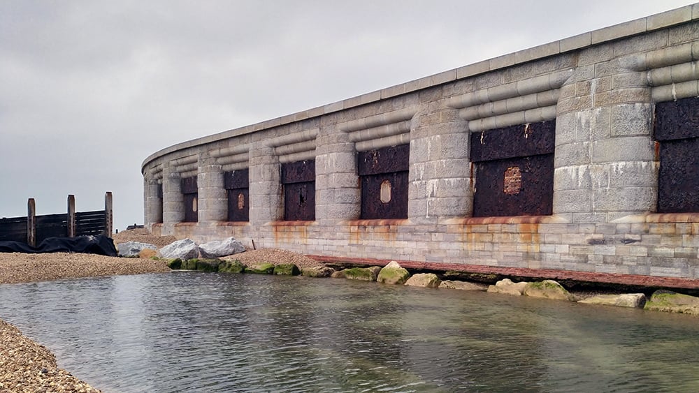 Exterior view of Hurst Castle facade with sea in front, and visible gap in foundation.