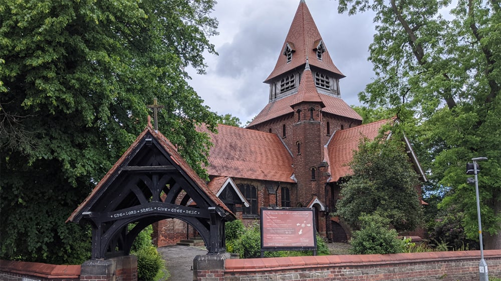 Exterior ground view of front gate in foreground and St Anne's church in background.