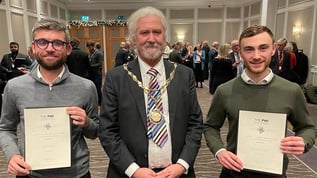 Two Geobear engineers holding PWI awards at an awards event