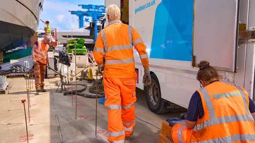 Three Geobear techs working on injection points on a concrete slab.