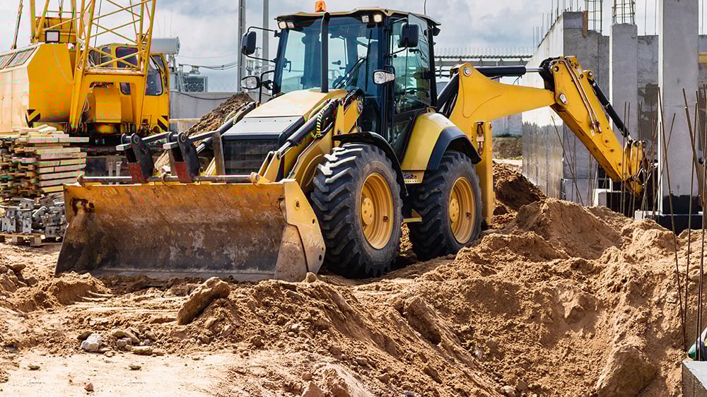 Excavator at a construction site with sandy soil