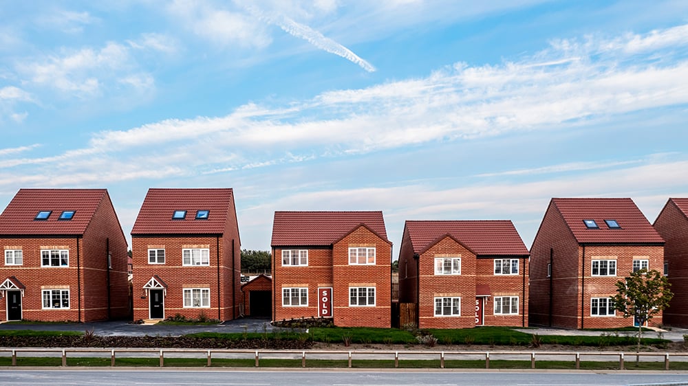 Row of five single family detached brick homes in a row.