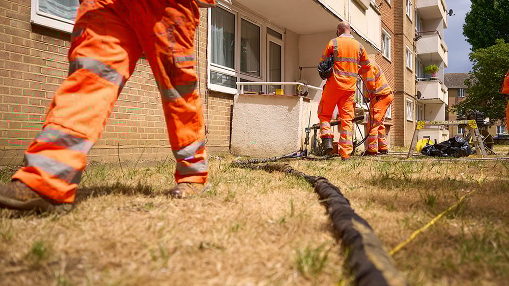 View of three Geobear techs working at the rear terraces of a block of flats.