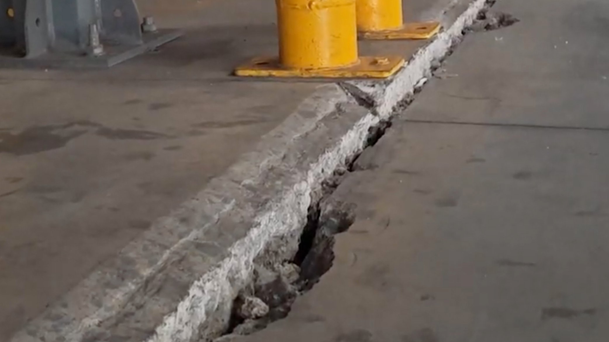 Detail view of failed concrete slab creating uneven surfaces in factory