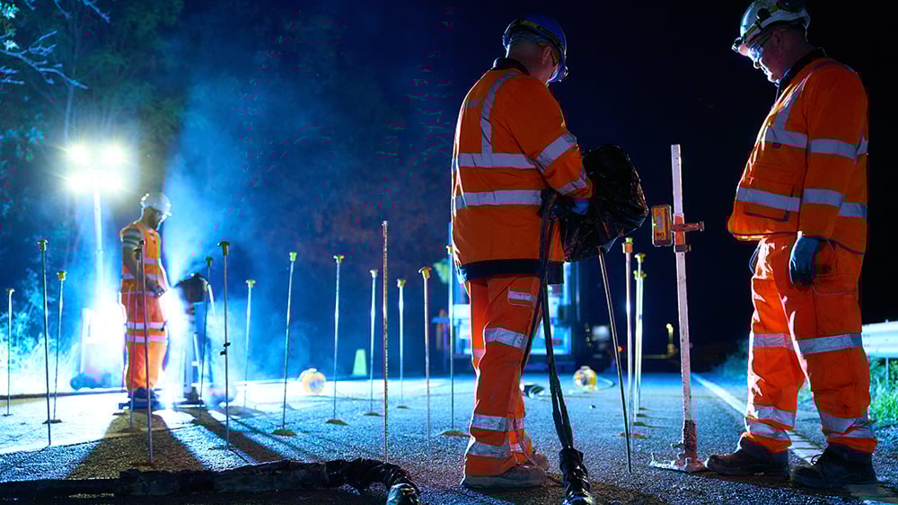 Geobear team injecting geopolymer while checking laser level measurements