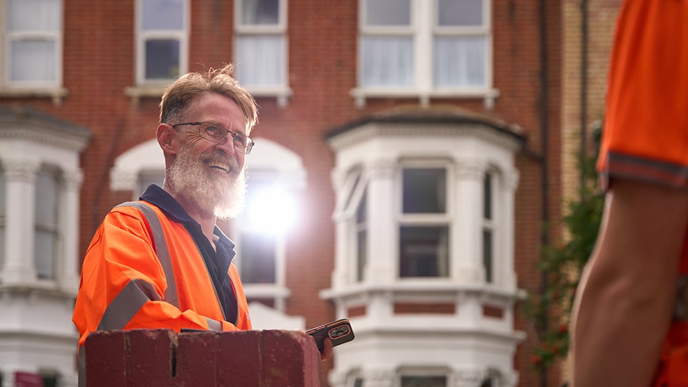 Geobear team leader smiling at site while talking to another tech.