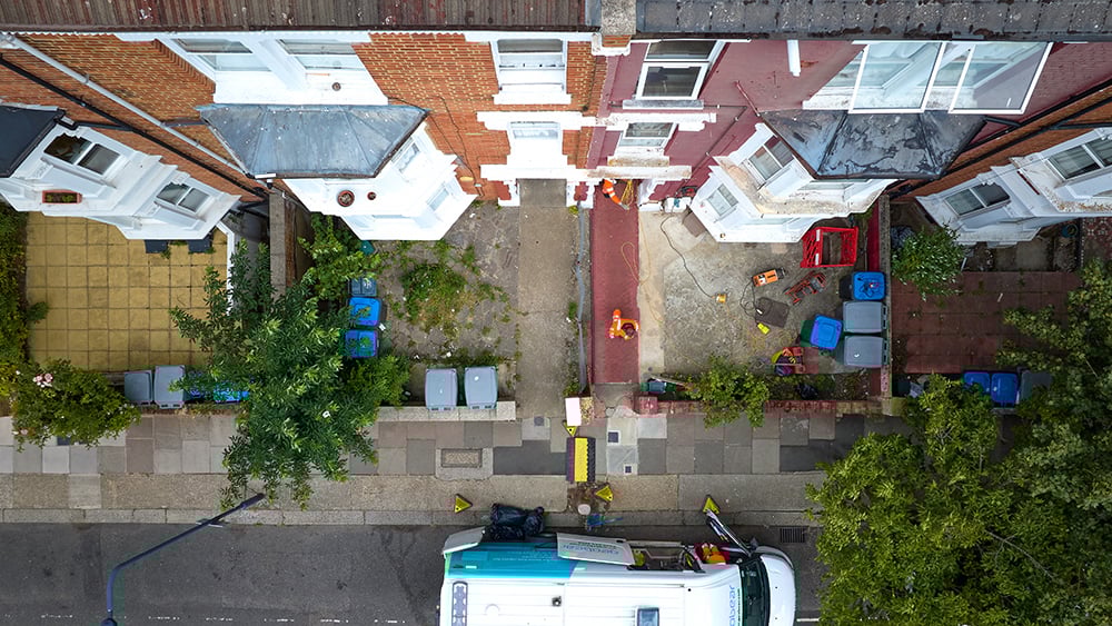 Aerial view of terrace homes in London with Geobear techs at work in the front of one home.