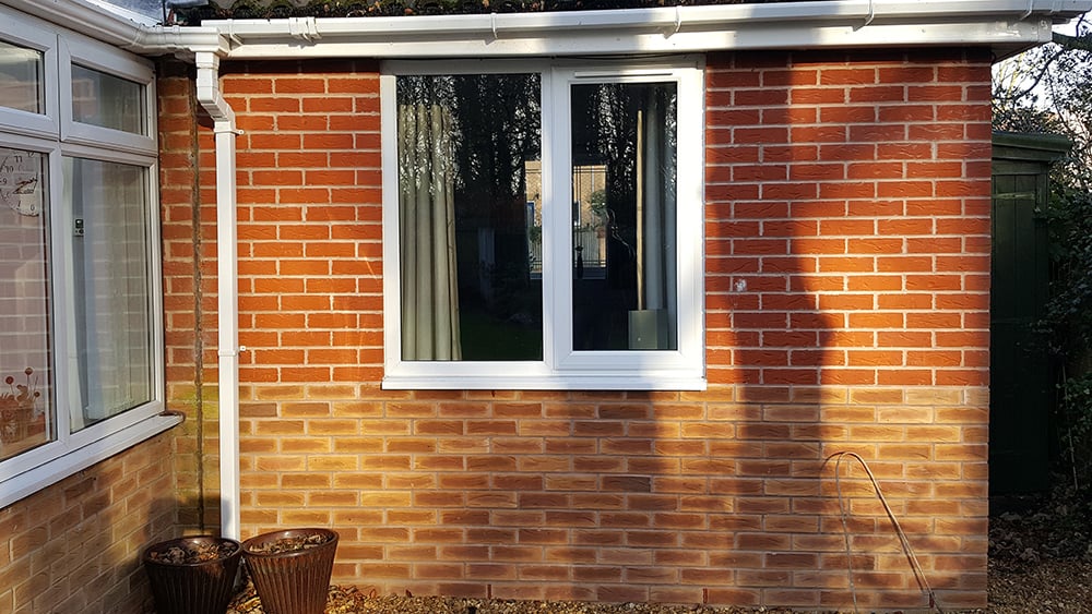 View of side elevation of brick exterior home extension which is subsiding