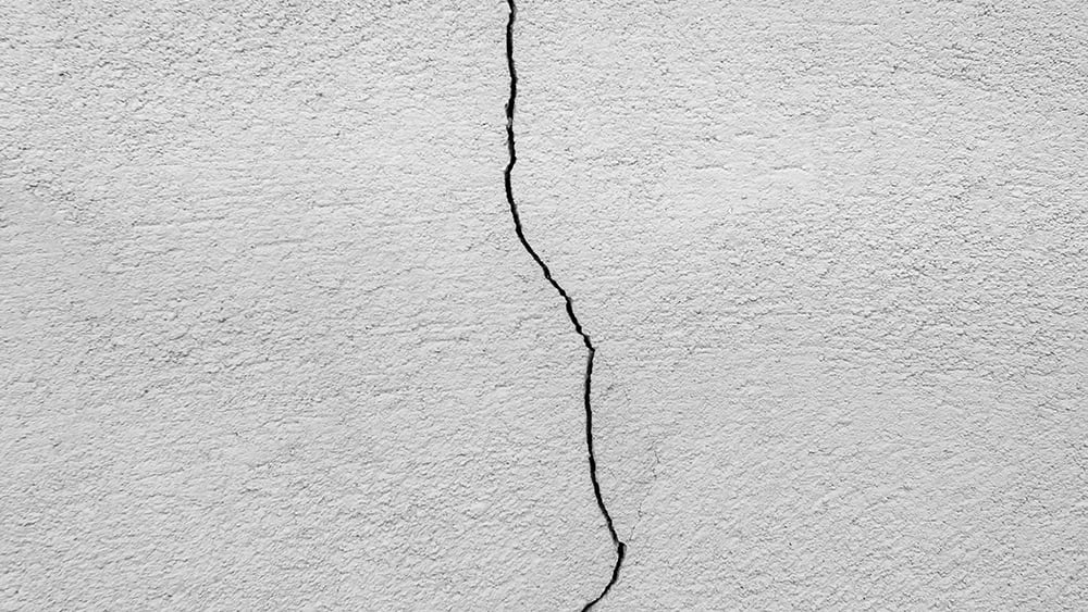 Close up view of a vertical crack in an exterior home wall