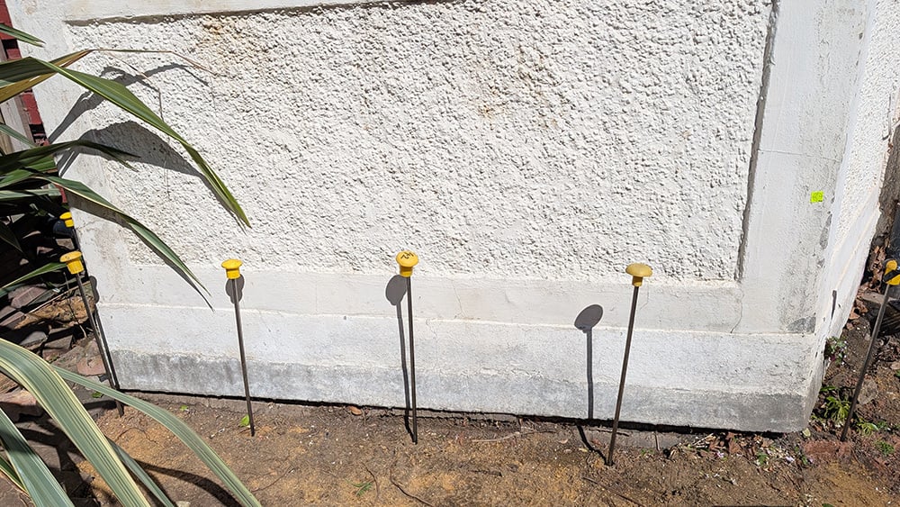 View of residential home extension with foundation exposed and injection tubes positioned along the front side.