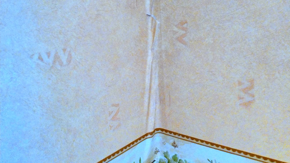 View of inside corner wall where the wallpaper is starting to crumple due to wall movement
