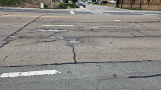 View of cracked road asphalt caused by sewer leakage
